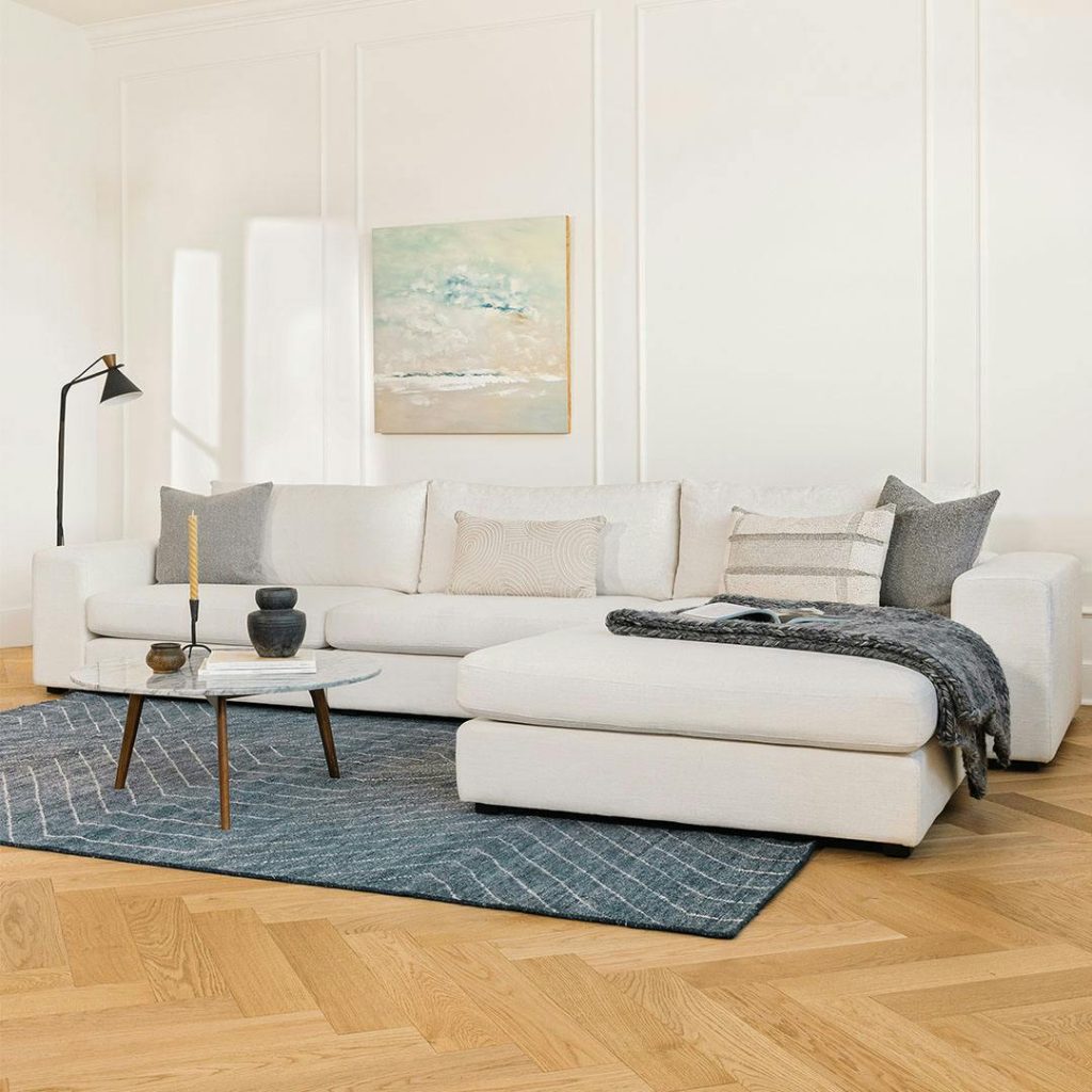 Article Beta Modular Sectional in L shape with cushions on top near a round marble coffee table in a modern and minimalist living room