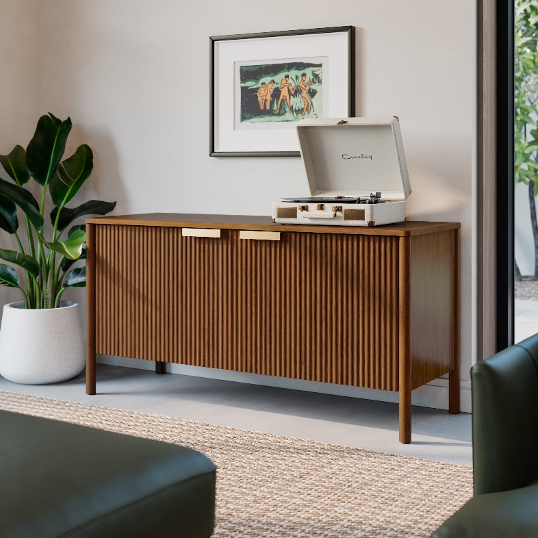 Article Liv 48" fluted wood Media Unit with storage and a disc player on top below a moutned painting near a sofa and a plant in a bright and modern living room