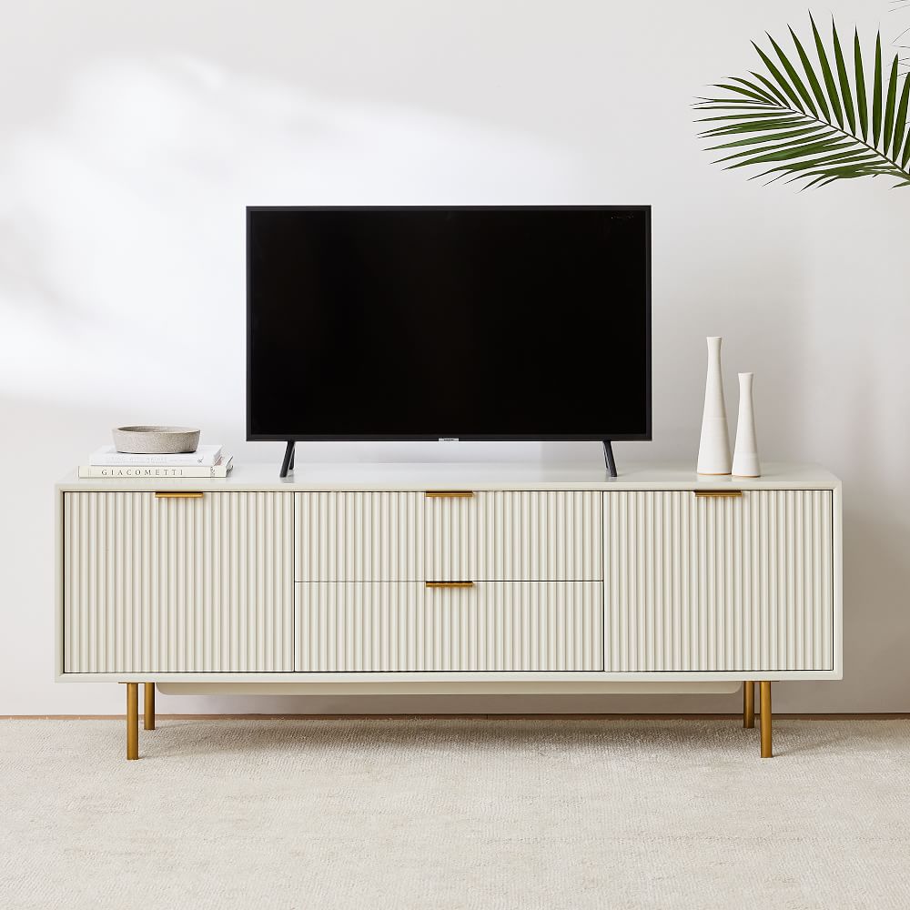 West Elm Quinn Media Console 68" with drawer storage and books, decorations and a black tv on top in a bright and minimalist living room