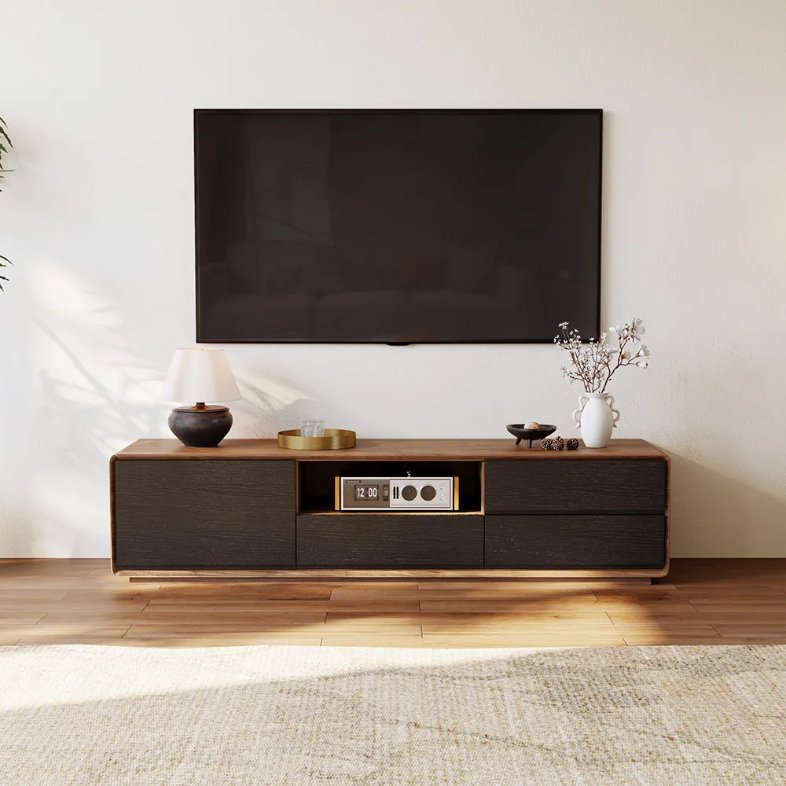 POVISON Modern Wood Black TV Stand with drawers and storage for game play and media and some decorations on top near a wall-mounted tv in a bright sitting room