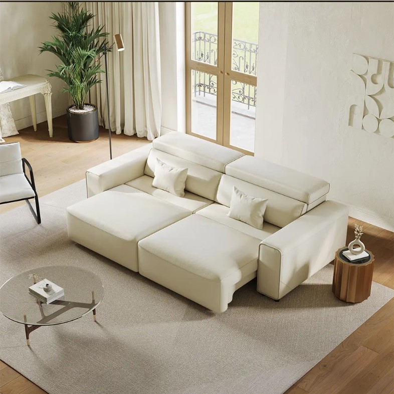 POVISON Dovaren-Power Sofa Bed in white leather with cushions and pull-out function near a round glass coffee table, a wood side table, a chair and a plant in a minimalist and bright living room