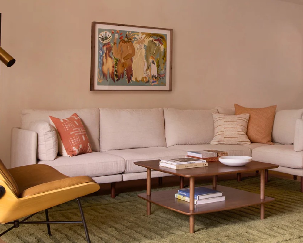 Burrow Field 5-Piece L Shaped Sectional with cushions near a rectangular wood coffee table and a chair in a modern and minimalist living room