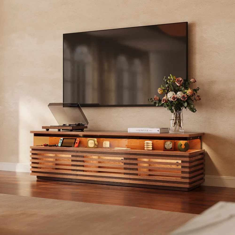 Selene-71" Horizontal Slatted TV Stand with Adjustable LED Lights and storage for a handheld game console, a disc player, books and decorations near a wall-mounted tv in a bright and cozy living room