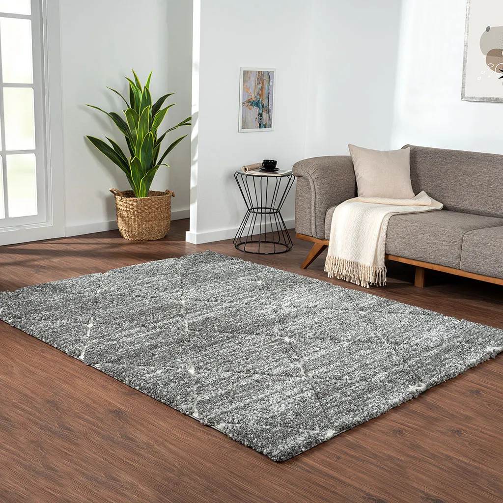 8' x 10' Modern Minimalist Diamond Shaped Rug near a grey sofa, a side table and a plant in a modern mid-century and cozy living room