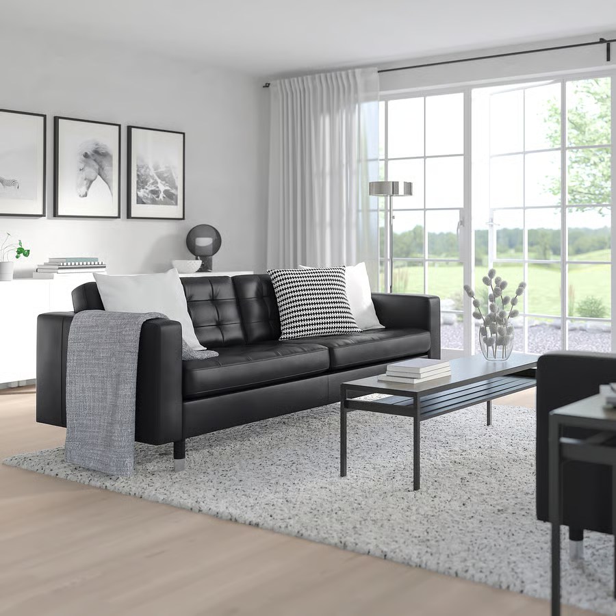 IKEA MORABO black Sofa with square arms and cushions near a rectangular coffee table and a white cabinet in a bright and modern living room