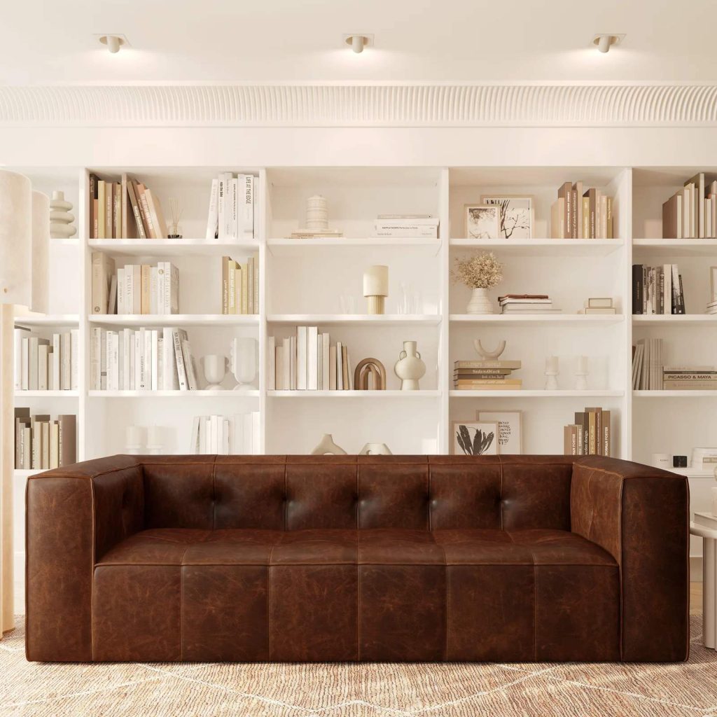 Poly & Bark Capa 96.5" Leather Sofa — Chocolate Brown with square arms near a shelf with books and decorations in a mid century modern living room
