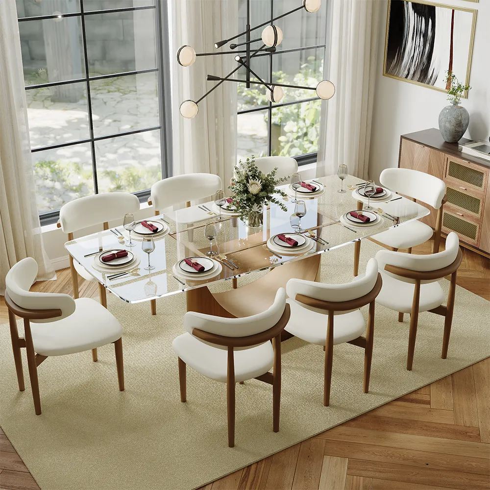 a glass-top dining table with plates, cups, and a plant as decoration on top near 8 white dining chairs and a console table in a modern and bright dining room