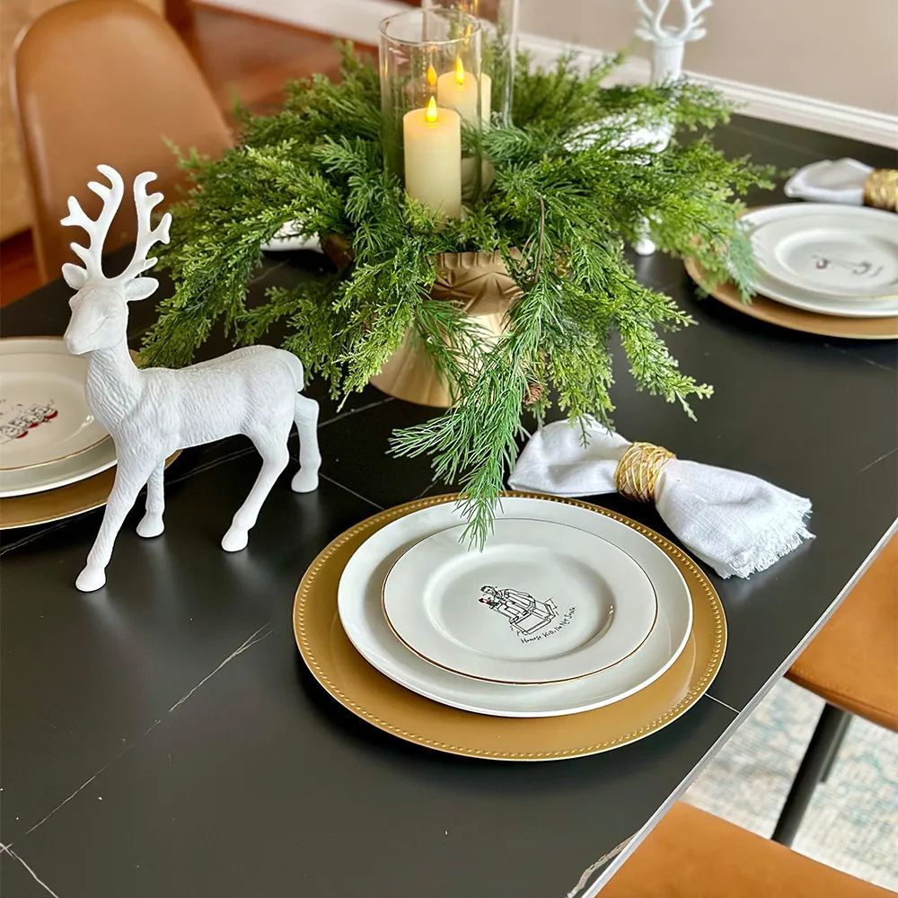 candles, plants and statues as decorations near plates on black marble dining table