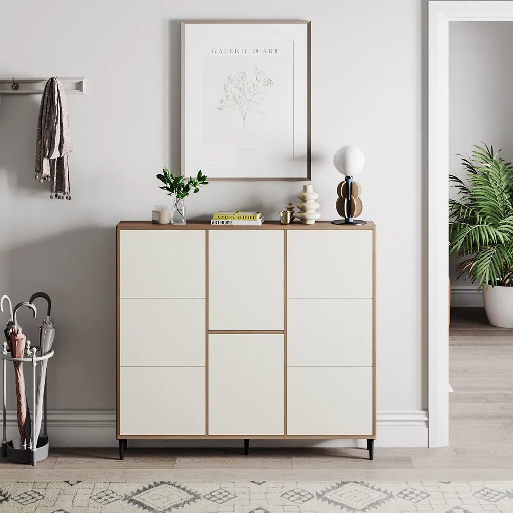 Organic modern entryway with a warm wood and ivory storage cabinet, minimalist decor, framed artwork, and indoor greenery.