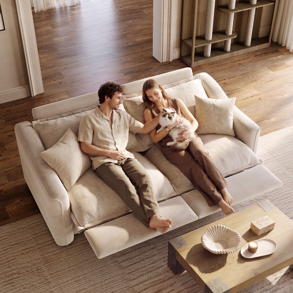 Couple relaxing on a beige reclining sofa with extended footrests while holding a cat in a warm modern living room.