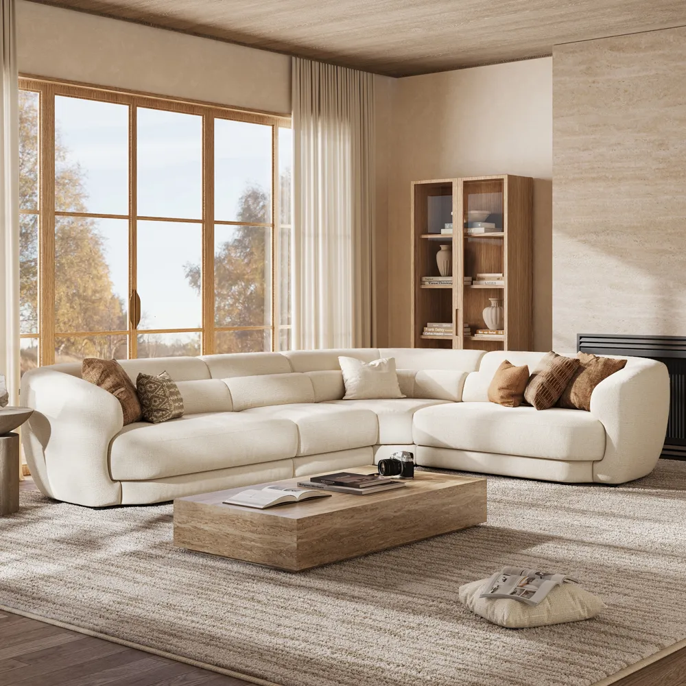 Large beige L-shaped sectional with open center seating, styled with corner pillows and a relaxed chaise-side accent.