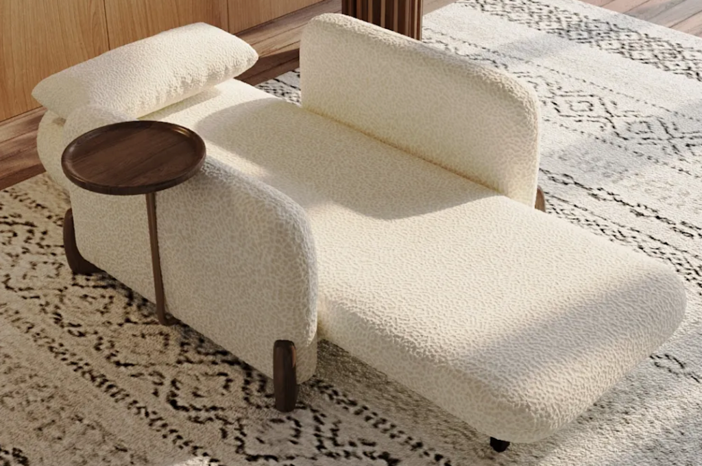 Cream-colored boucle fabric power recliner lounge chair fully extended next to a small wooden side table.