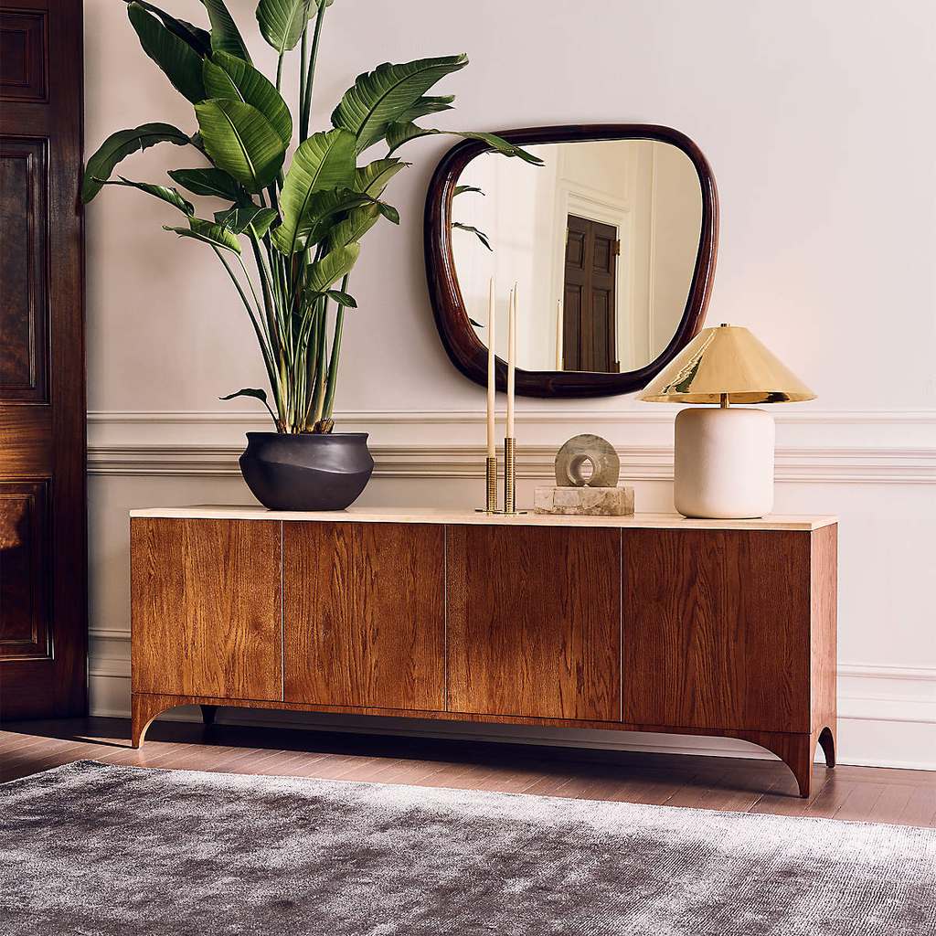CB2 Roane 80" Oak Wood Media Console with a plant, a lamp and some decorations on top below a mirror in a modern living room