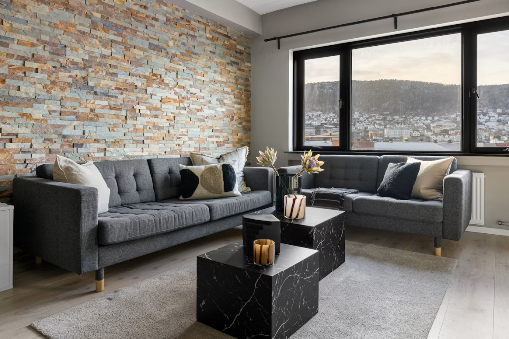 Deep charcoal grey modern sofa sets arranged with black marble block coffee tables in a stylish apartment.