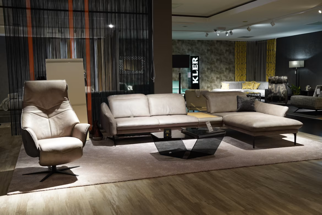 Sleek geometric black glass living room table sets arranged on a large area rug in a furniture showroom.