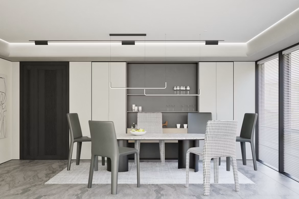 Sleek sintered stone dining table with dark pedestal legs, styled with minimalist grey and houndstooth chairs.