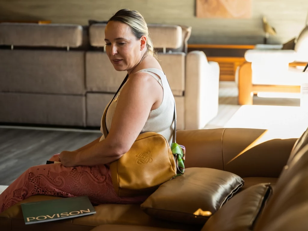 A lady sitting on a leather sofa to feel its support