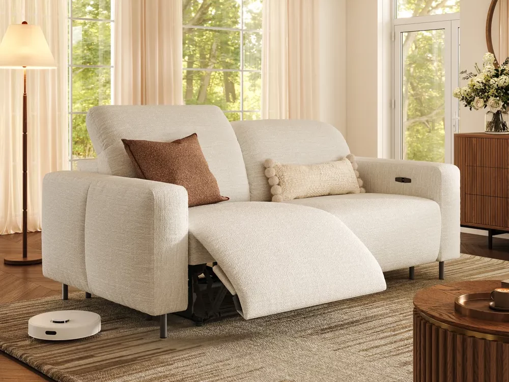 Elara-Dual Power Reclining Loveseat with pet friendly fabric near a round coffee table, a console table with a flower on top and a floor lamp in a bright living room