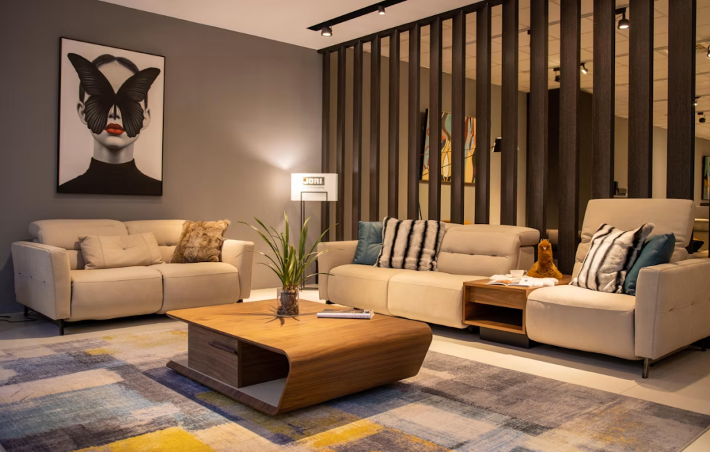 Contemporary modern sofa sets in beige leather styled with striped pillows and a curved wooden coffee table.