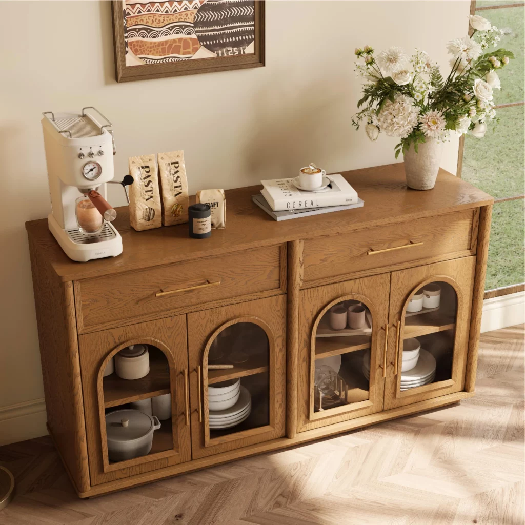 Light walnut buffet cabinet styled near a lake home entry with baskets, folded towels, ceramic decor, and warm natural lighting.