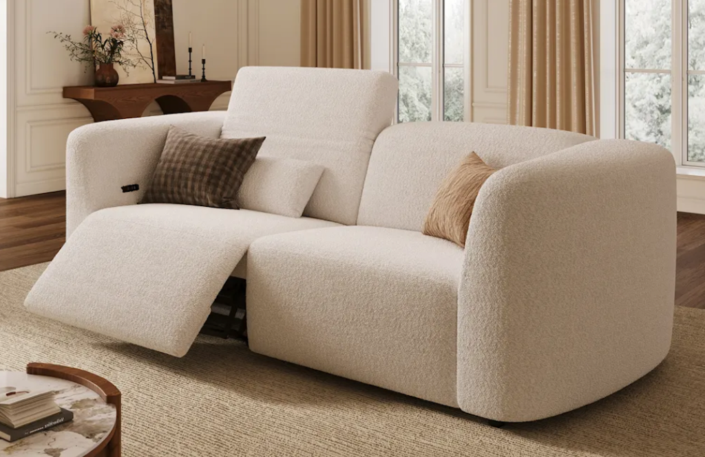Textured cream boucle power lift recliners with one side fully extended over a minimalist patterned rug.