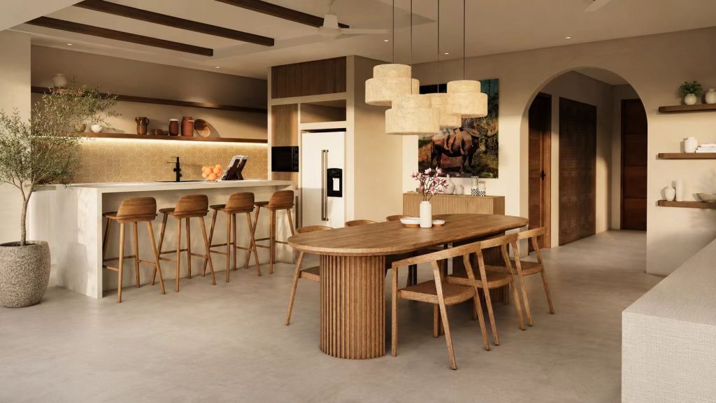 Oval wooden dining table with a fluted pedestal base and matching chairs in a warm, open-concept kitchen space.