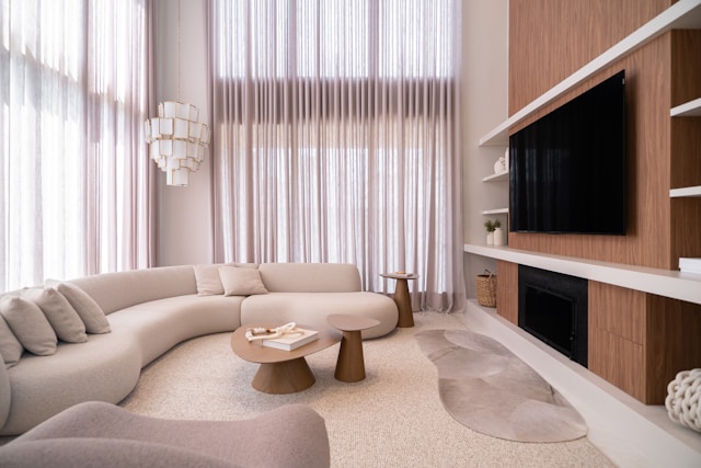 Modern living room for watching sports on TV, with curved sofa, side table and coffee table