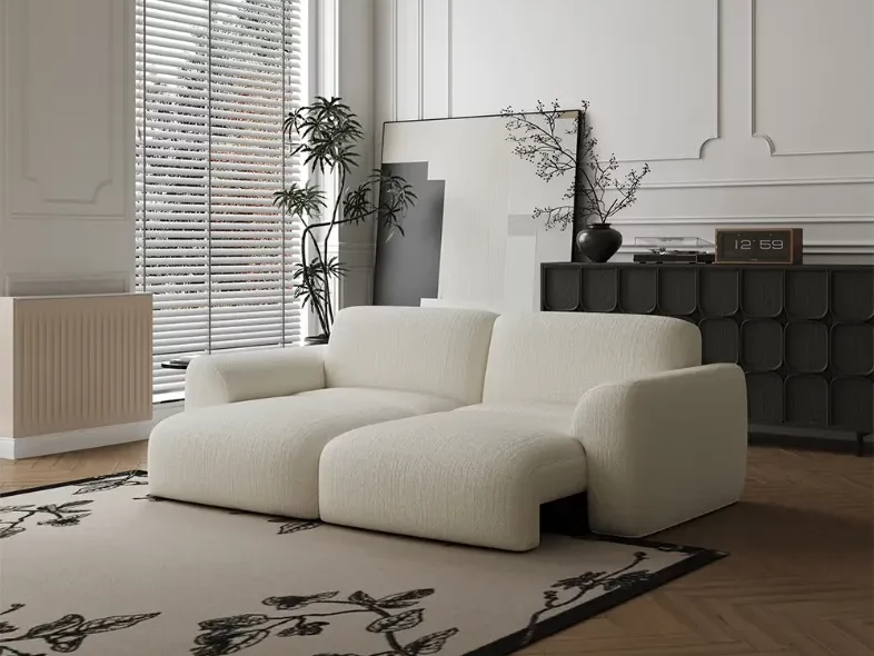 Povison Aurora Power Sofa Bed near a plant and a black wood cabinet with a plant, a disc player and a clock on top in a minimalist living room