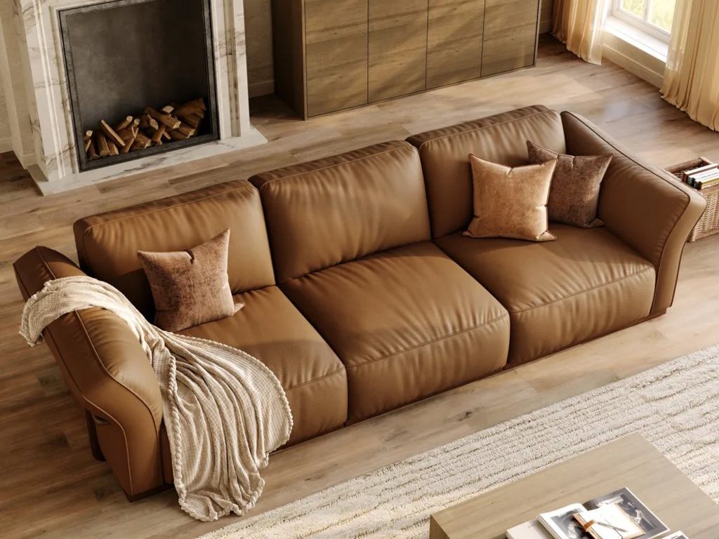 Cronus-Brown Genuine Leather Modular Sofa near a rectangular wood coffee table, a wood console table with a book and decoration on top and a fireplace in a bright living room