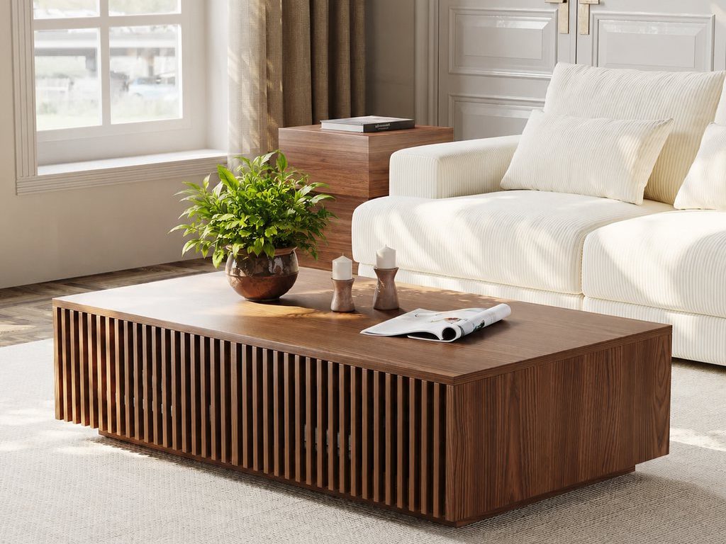 Modern living room with a wood coffee table, green indoor plant, cream sofa, soft natural light, and warm neutral decor.