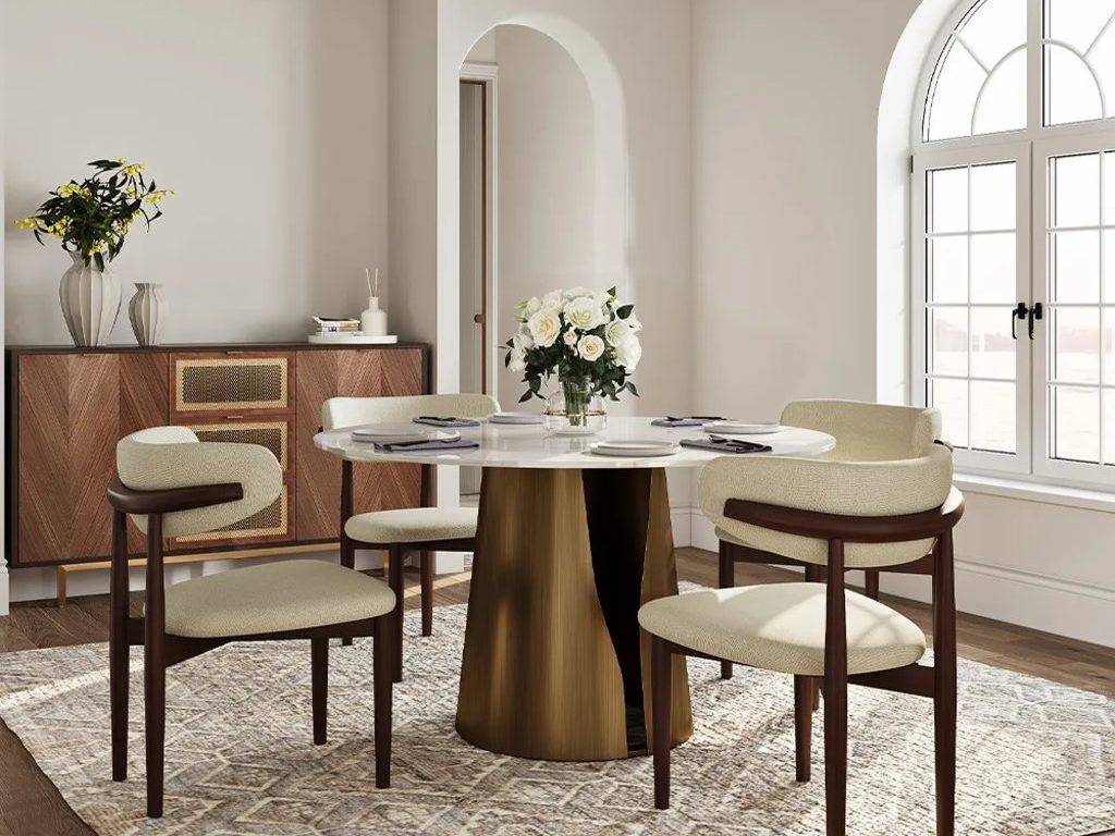 Elegant dining room with round white table, cream upholstered chairs, patterned area rug, wood sideboard, arched window, and black chandelier.