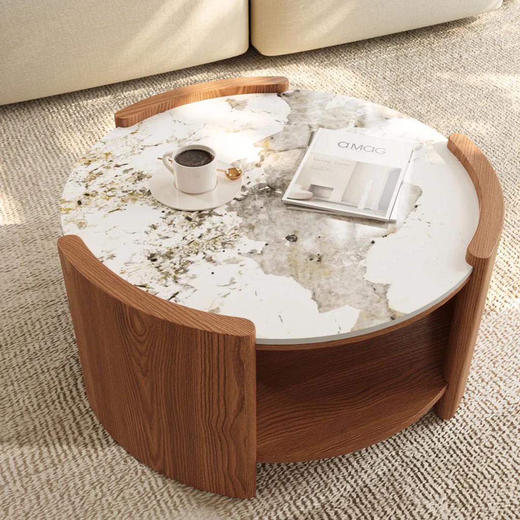 Round white marble-look coffee table with a walnut wood base, styled with a coffee cup and a minimalist design book.