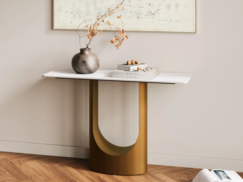 Modern wood-and-white console table styled with a textured vase, dried branches, and stacked books beneath abstract wall art.