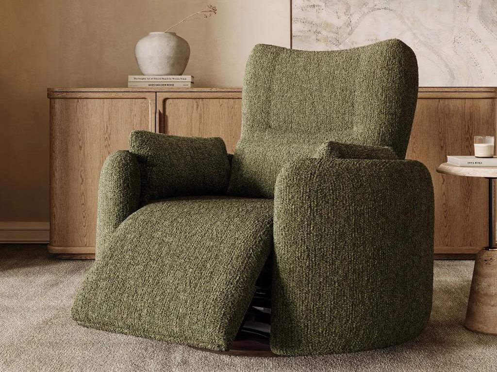 Green textured swivel recliner chair with an extended footrest in a warm living room, placed in front of a wood sideboard and neutral wall art.