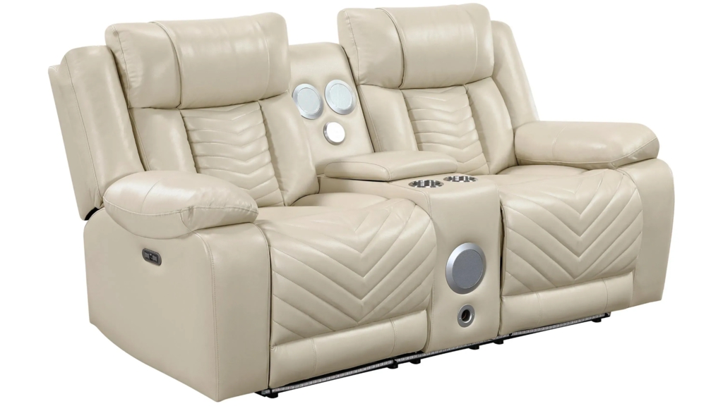 Cream leather power reclining loveseat with two padded seats, a center console with cupholders, built-in speakers, and chevron-stitched chaise footrests on a white background.