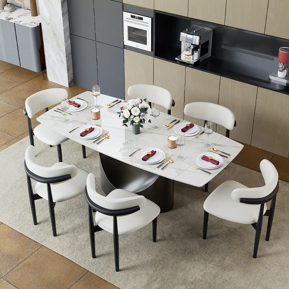 White rectangular dining table with six curved chairs in an open-plan kitchen and dining area.