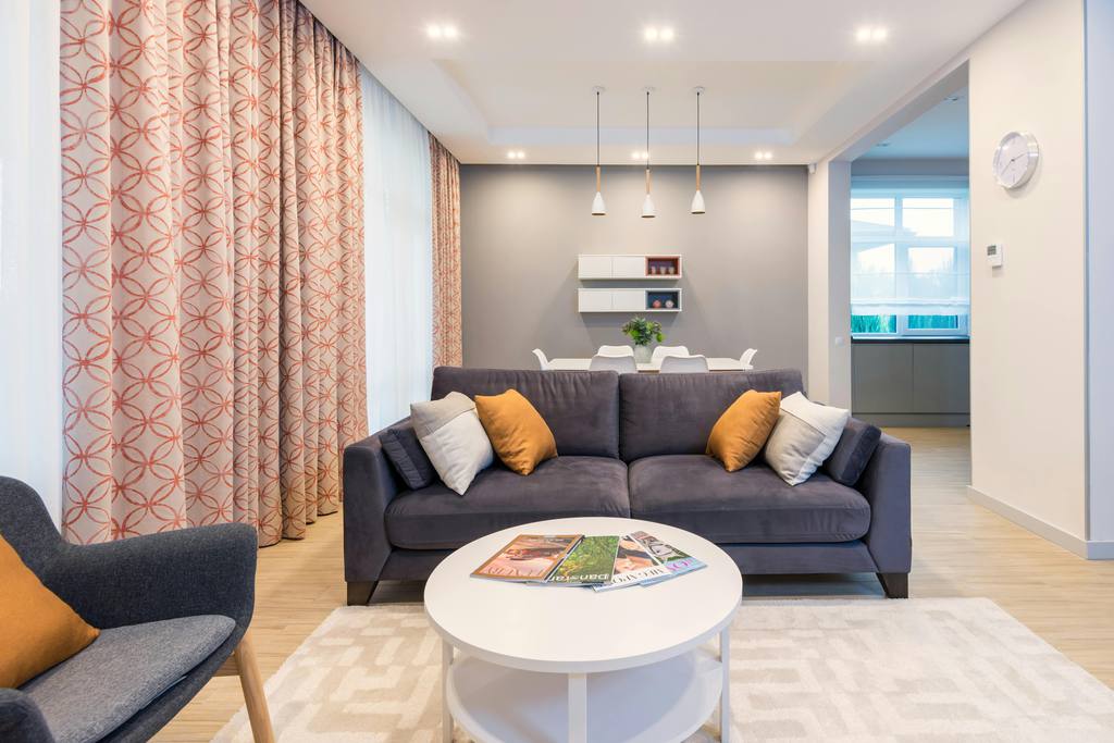 a compact living room with a sofa, an accent chair and a round coffee table which leave enough room for passing-through
