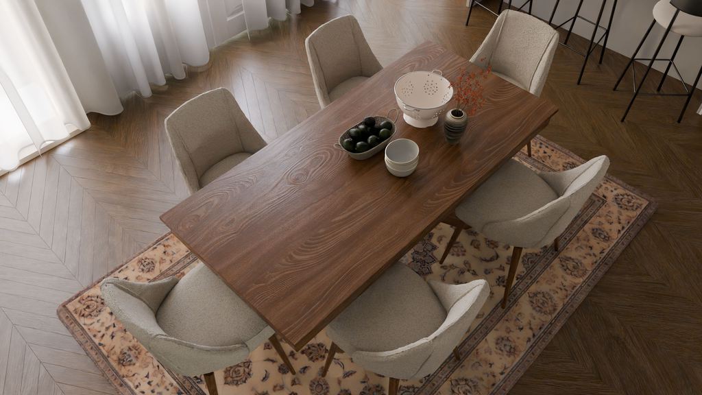 Warm minimalist dining room with a wood table, upholstered chairs, patterned rug, soft curtains, and simple tabletop decor.