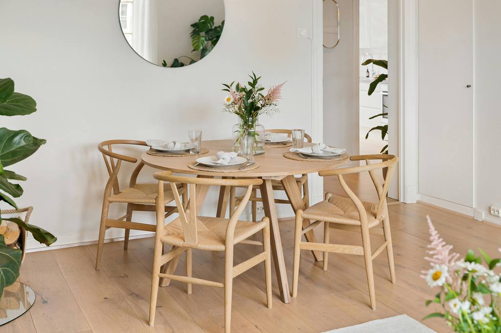 Maple-tone wooden table and chairs in a modern dining room.