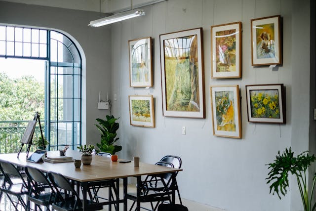Bright apartment dining area with framed wall art and simple furniture, showing decor pieces that can wait after move-in.