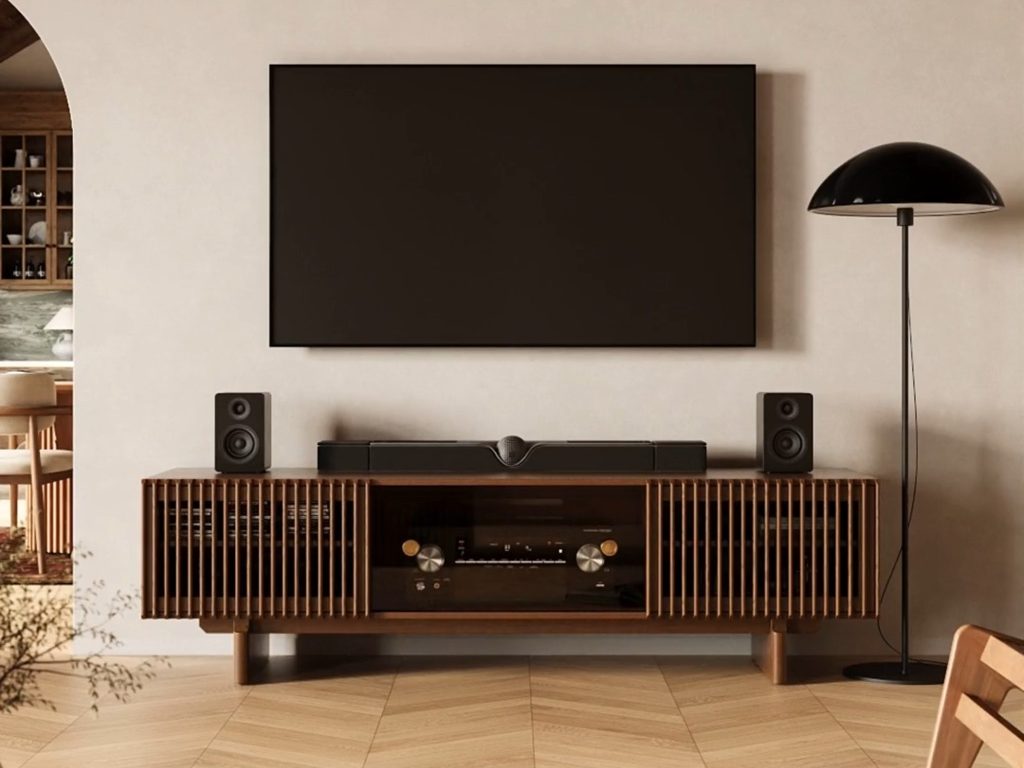 Modern Scandinavian media wall with a slatted wood TV stand, wall-mounted TV, speakers, floor lamp, and warm neutral living room decor.