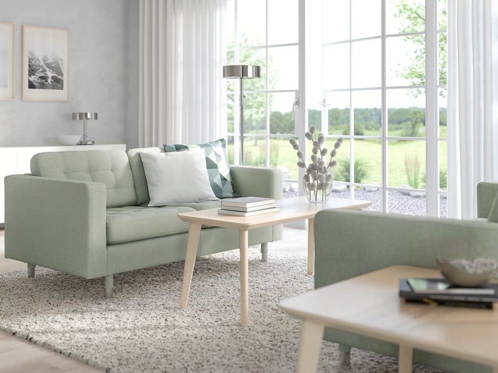 IKEA MORABO Loveseat with square arms and cushions near a rectangular wood coffee table and a wood side table in a bright and modern living room