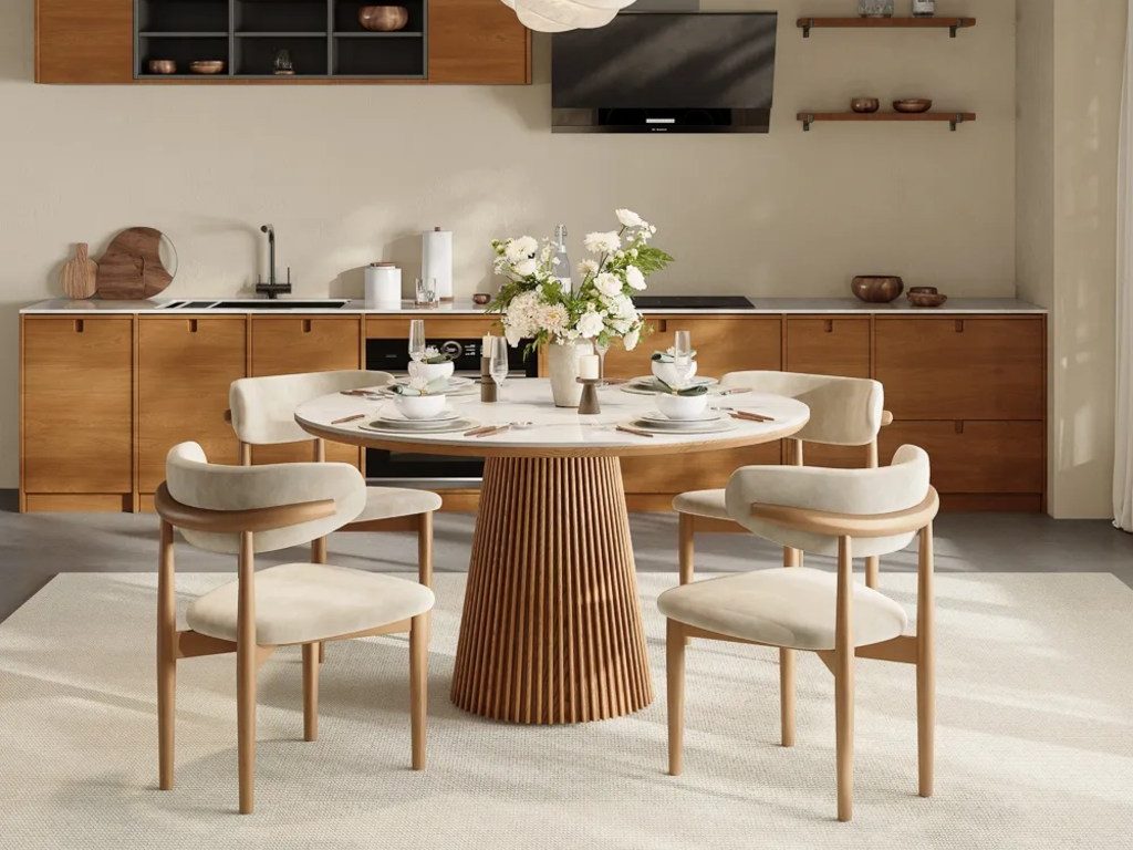Silva-Round Glossy Sintered Stone Dining Table with plates, dishes, candles and vase on top and four chairs around it in a bright dining room