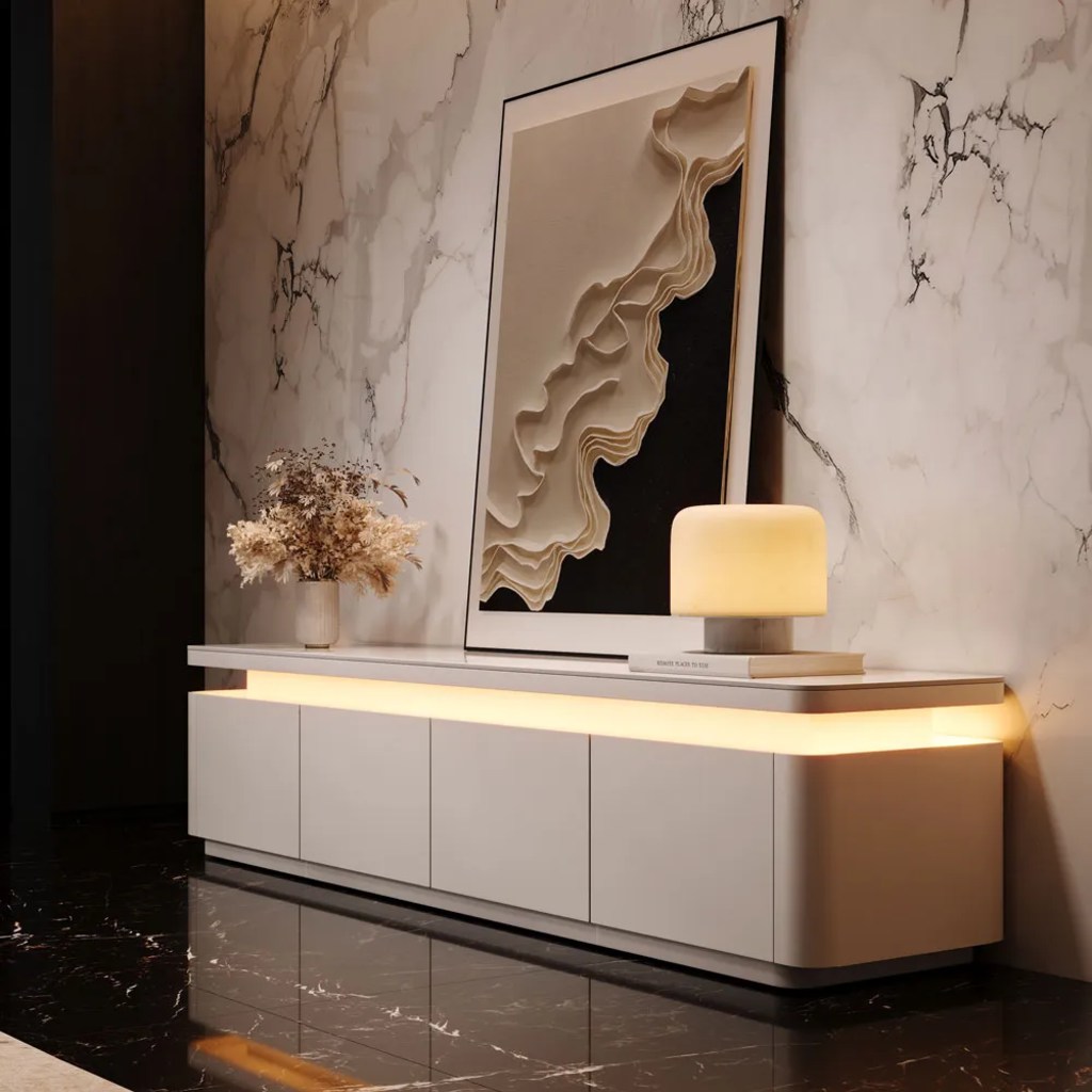 Aether-71" Modern White Media Console with adjustable LED lights, a lamp on a book, a painting and a vase on top in a modern living room against a white marble wall