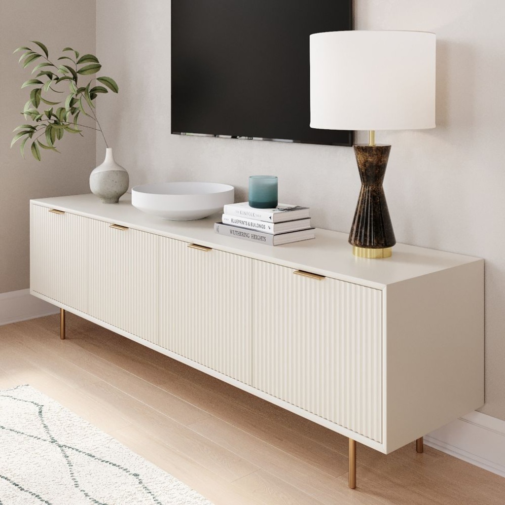 West Elm Quinn 80" white Media Console with storage and a lamp, some books, a tray and a plant on top against a white wall with a mounted tv in a bright and minimalist living room