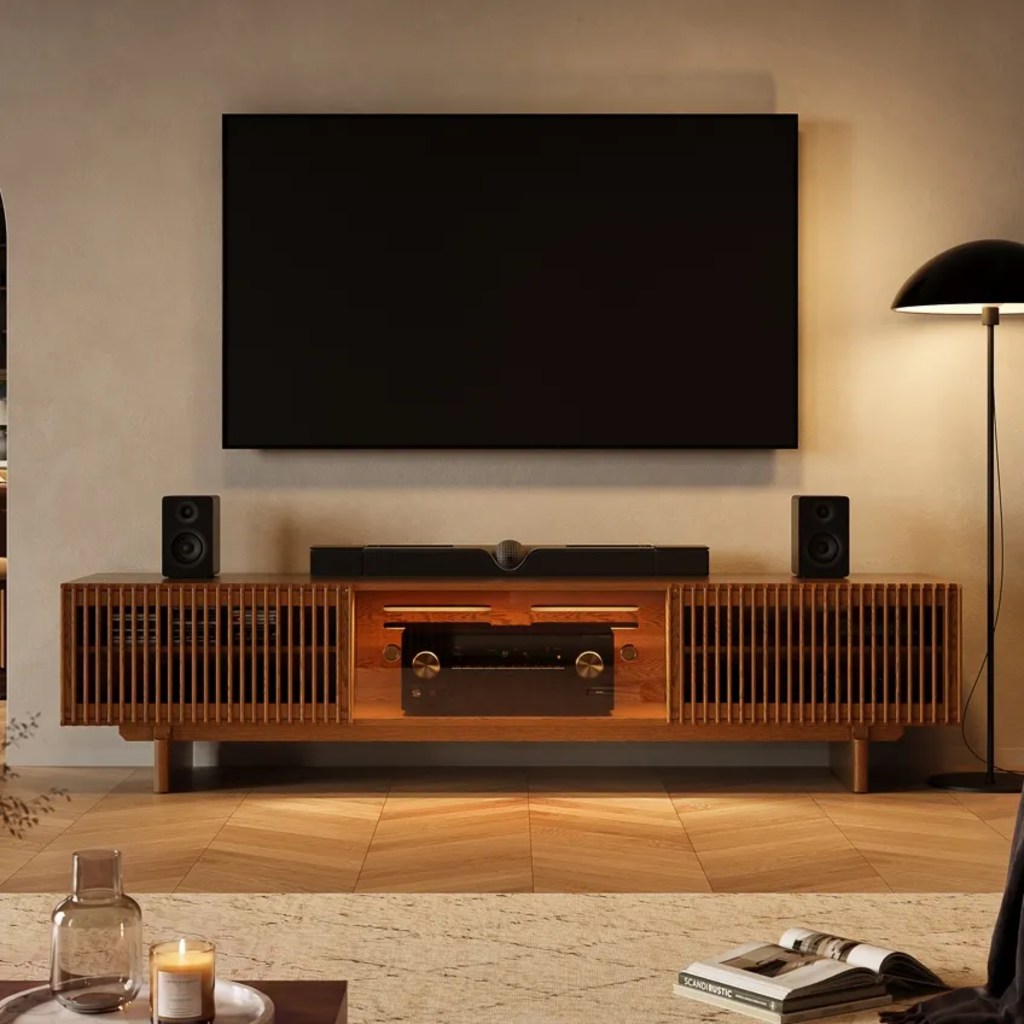 POVISON Arboren-95'' Mid-Century Modern TV Stand with storage for consoles and soundbars on top near a floor lamp below a wall-mounted tv in a mid century modern living room