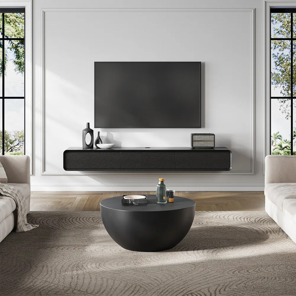 a minimalist floating media console with a tray, a radio and some decorations against a white wall with a mounted tv in a cozy and bright living room near sofas and a coffee table