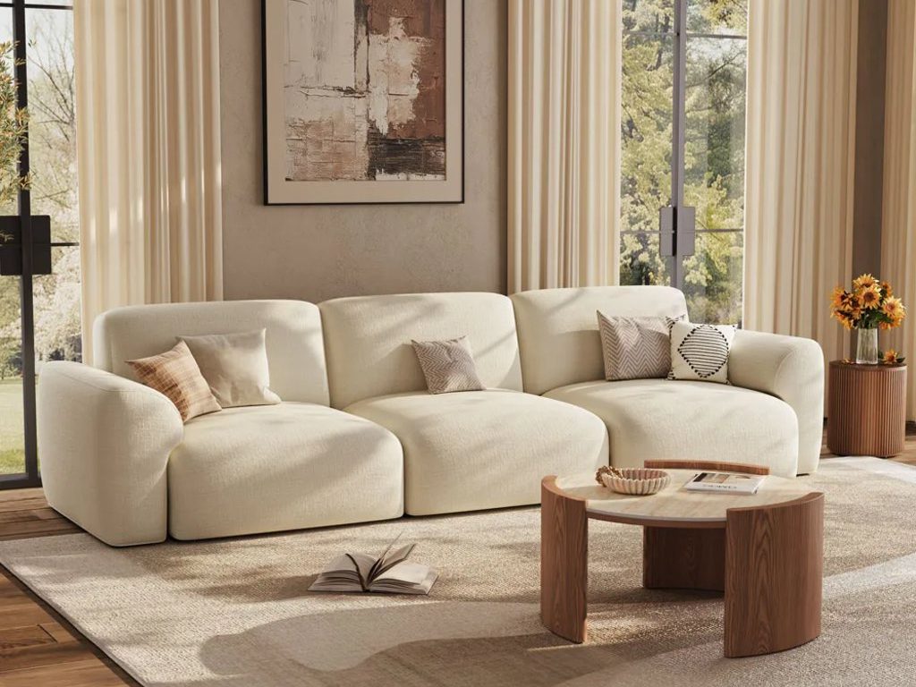 Povison 31" Round Matte Sintered Stone Coffee Table near a white fabric sofa beside a round tufted side table with a vase on top in a modern transitional living room