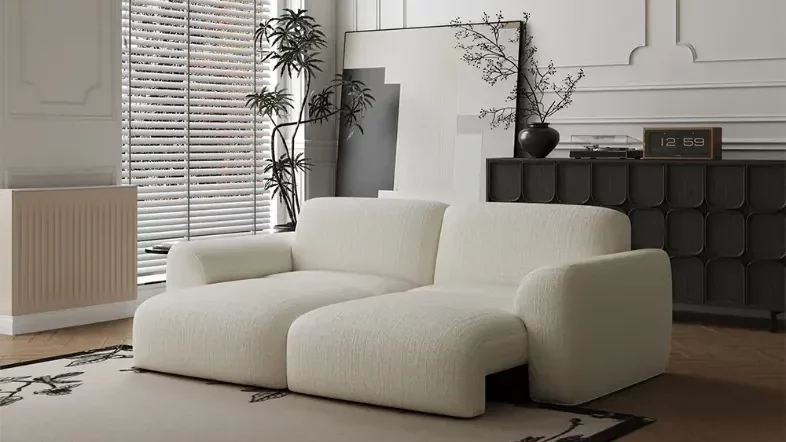 Povison Aurora Power Sofa Bed with motorized function near a plant, a painting and a console table with a plant and a clock on top in a minimalist living room