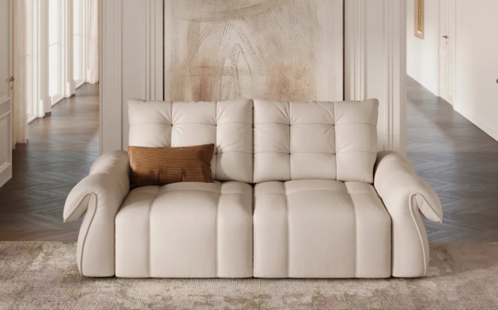 Elegant cream white tufted sofa bed in its closed position, styled in a luxurious hallway setting with a large painting.